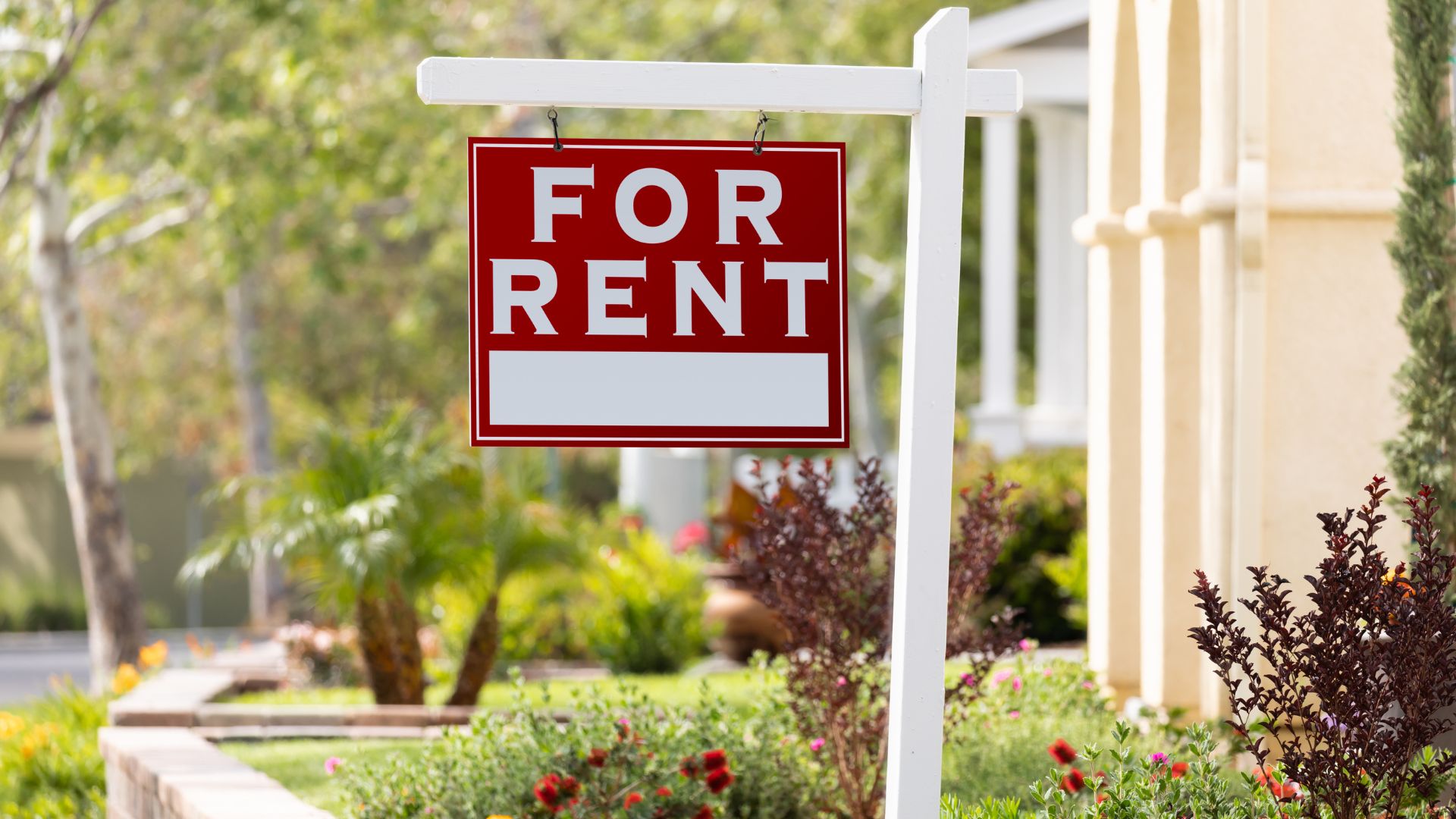 red and white for rent sign outside of a home